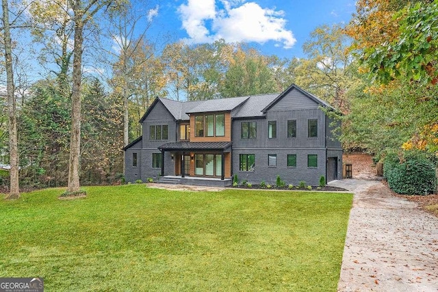 view of front of house featuring a garage, covered porch, and a front lawn