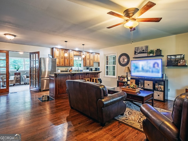 living room with ceiling fan, a healthy amount of sunlight, sink, and dark wood-type flooring