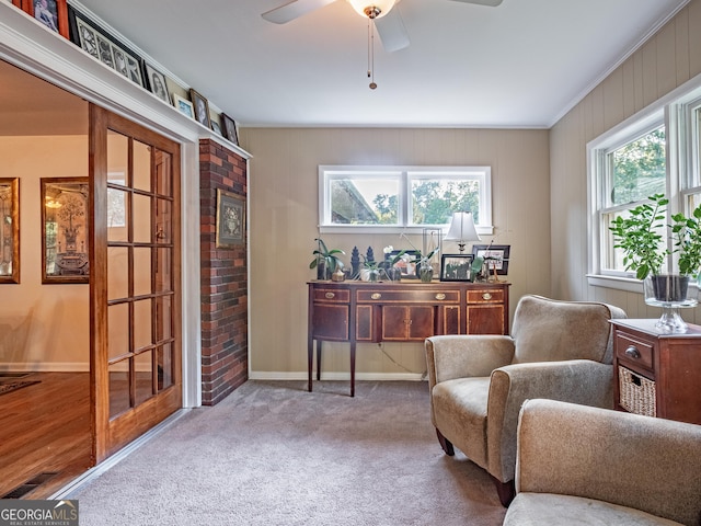 sitting room featuring carpet floors, ceiling fan, and crown molding