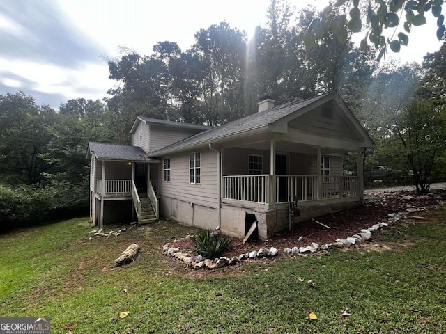 view of side of home with a lawn and covered porch