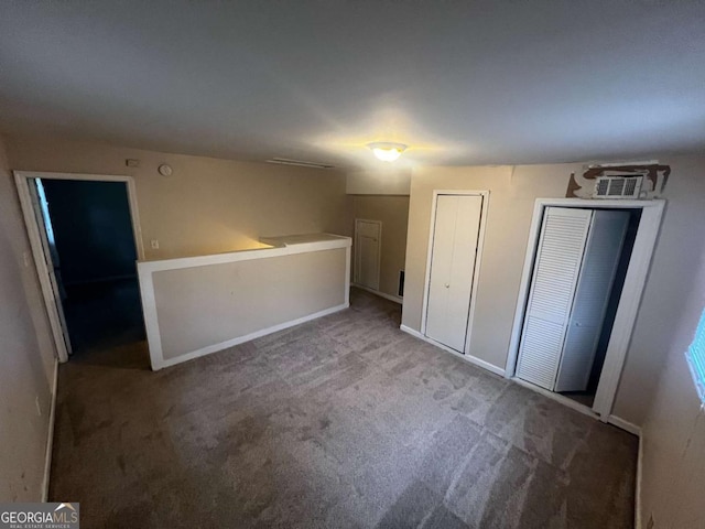 unfurnished bedroom with carpet flooring and two closets