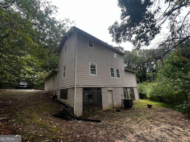 rear view of house featuring central AC