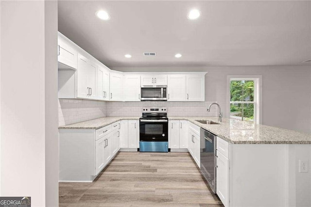 kitchen with white cabinetry, sink, kitchen peninsula, and stainless steel appliances