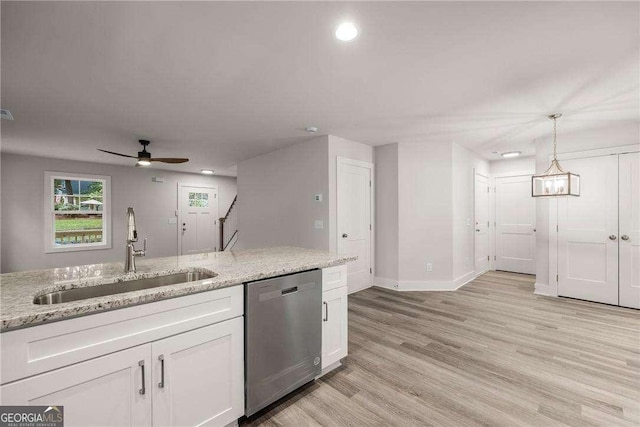 kitchen with light stone countertops, dishwasher, sink, hanging light fixtures, and white cabinets