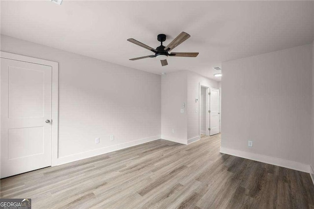 empty room with light hardwood / wood-style flooring and ceiling fan