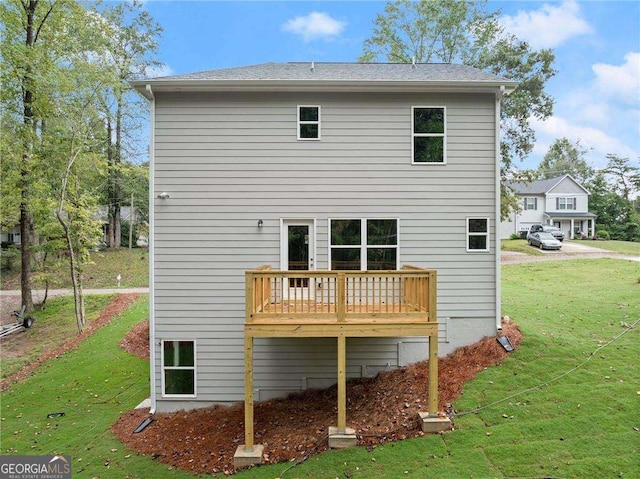 back of property featuring a lawn and a deck