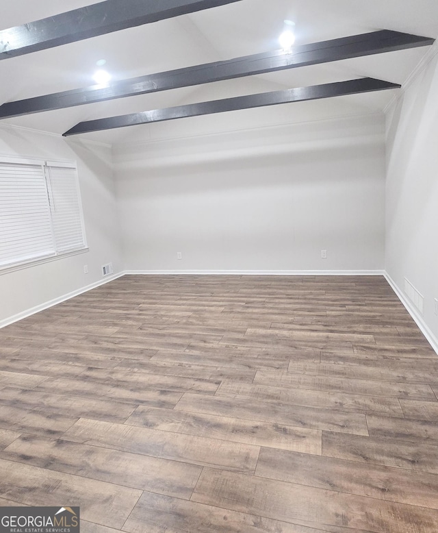 empty room with vaulted ceiling with beams and wood-type flooring