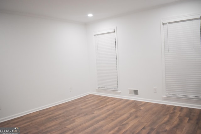 empty room featuring crown molding and dark wood-type flooring