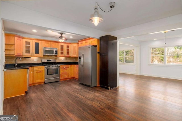 kitchen featuring ceiling fan, sink, dark wood-type flooring, stainless steel appliances, and backsplash