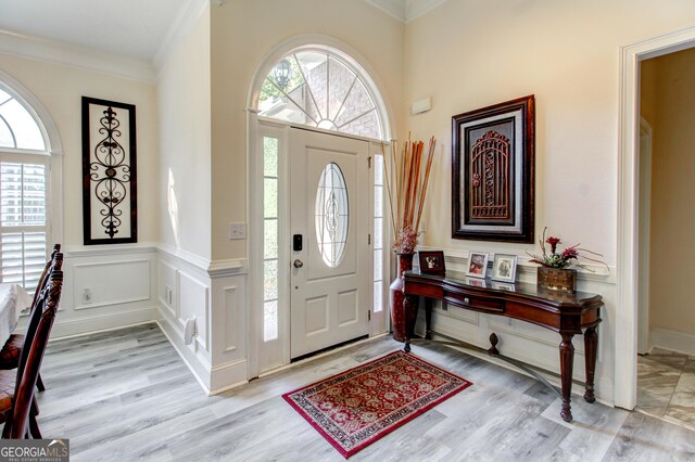 entryway featuring light wood-type flooring and ornamental molding