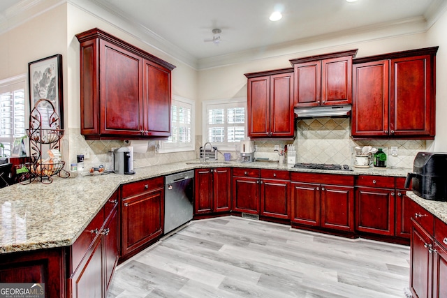 kitchen with light stone countertops, sink, tasteful backsplash, light hardwood / wood-style flooring, and appliances with stainless steel finishes