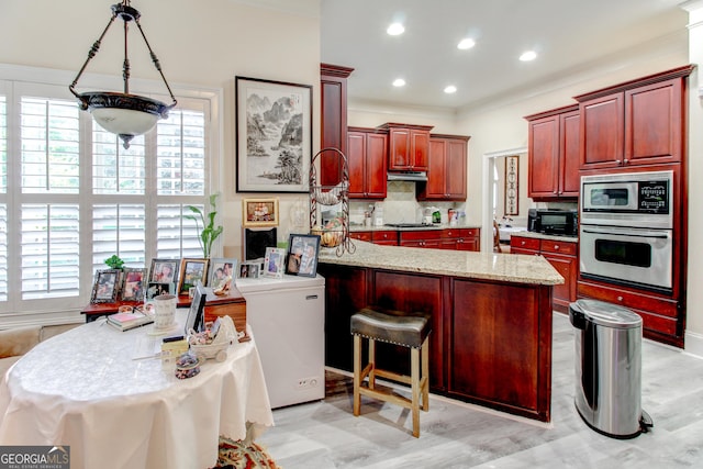 kitchen with light stone countertops, tasteful backsplash, stainless steel appliances, a center island with sink, and plenty of natural light