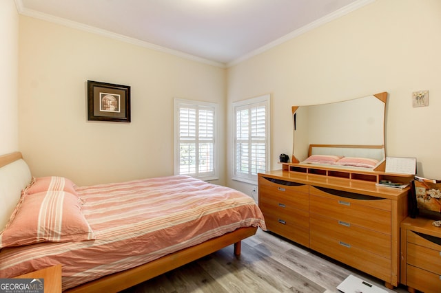 bedroom with light hardwood / wood-style floors and crown molding