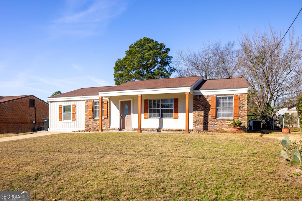 ranch-style house with cooling unit and a front lawn