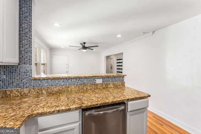 kitchen featuring light hardwood / wood-style floors, decorative backsplash, stone countertops, crown molding, and stainless steel dishwasher