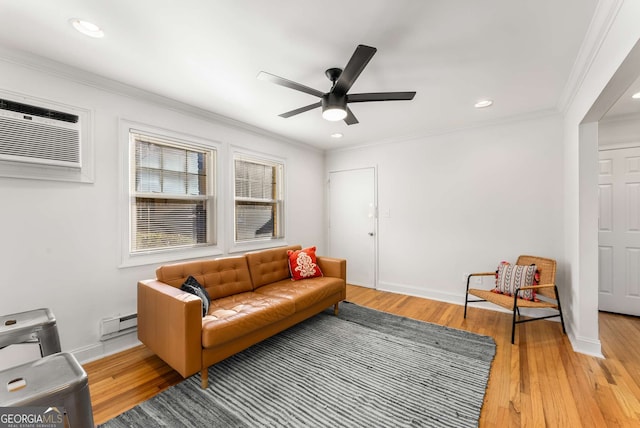 living room with baseboard heating, a wall mounted AC, light wood-type flooring, ceiling fan, and crown molding