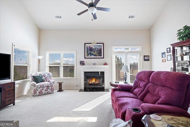 living room with carpet, ceiling fan, and a high end fireplace