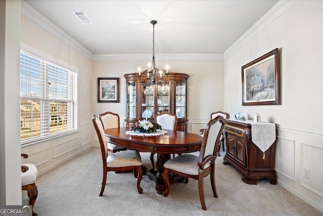 carpeted dining area with a chandelier and crown molding