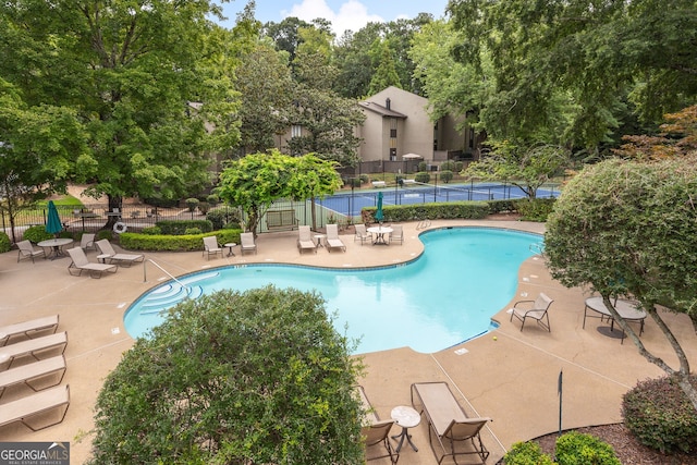 view of pool featuring a patio area and tennis court
