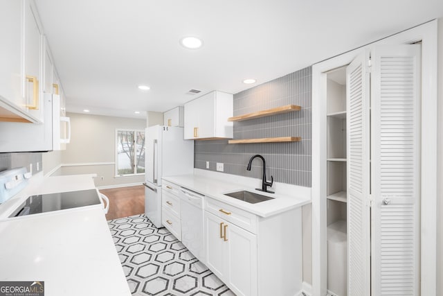 kitchen featuring white appliances, white cabinets, sink, light hardwood / wood-style flooring, and decorative backsplash