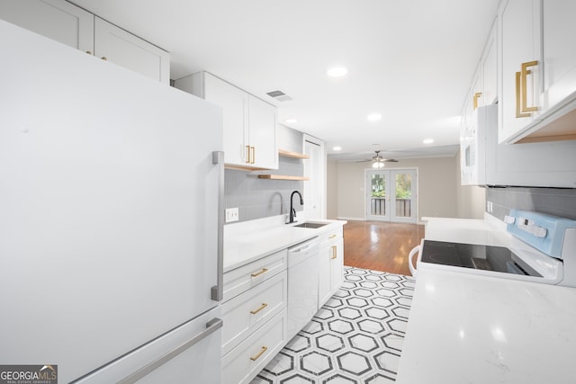 kitchen featuring french doors, white appliances, white cabinetry, and sink