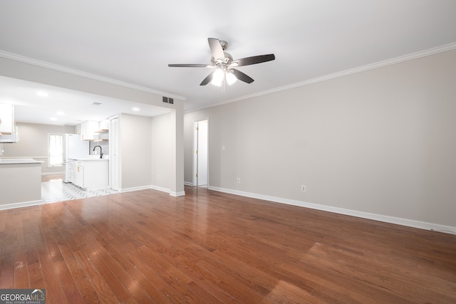 unfurnished living room featuring hardwood / wood-style flooring, ceiling fan, crown molding, and sink