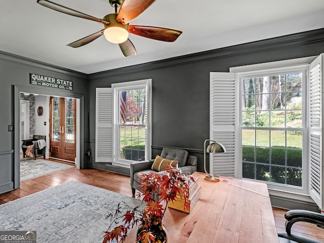 interior space with ceiling fan, french doors, ornamental molding, and light wood-type flooring