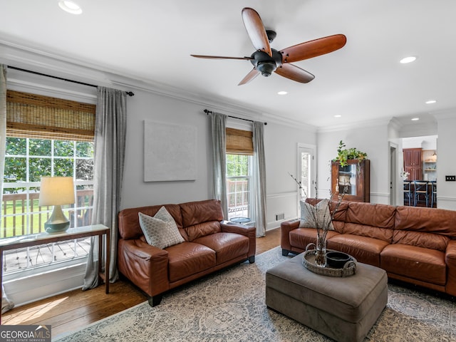 living room with crown molding, ceiling fan, and wood-type flooring