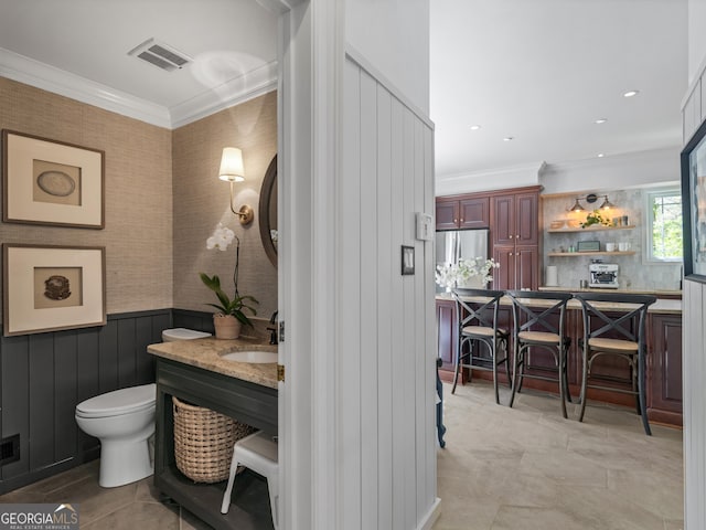 bathroom featuring vanity, toilet, and ornamental molding