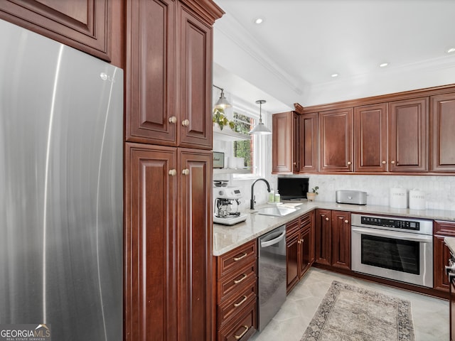 kitchen with sink, decorative backsplash, light stone countertops, appliances with stainless steel finishes, and decorative light fixtures