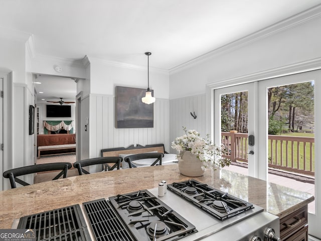 kitchen featuring light stone countertops, ceiling fan, french doors, hanging light fixtures, and crown molding