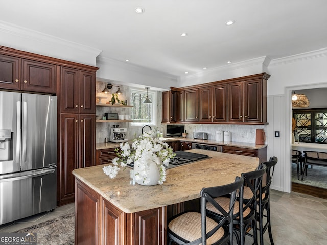 kitchen with light stone counters, a breakfast bar area, decorative backsplash, a kitchen island, and appliances with stainless steel finishes