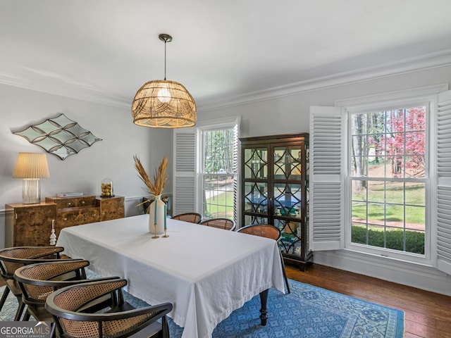 dining area featuring ornamental molding and dark wood-type flooring