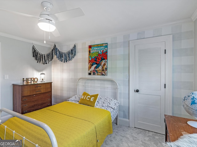 carpeted bedroom with ceiling fan, a closet, and ornamental molding