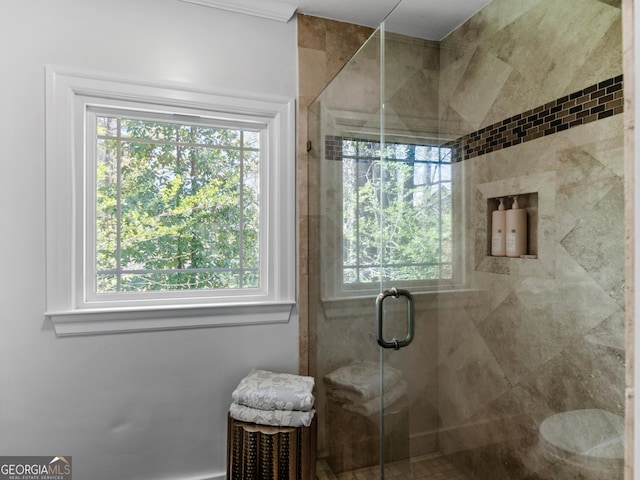 bathroom with a shower with door and a healthy amount of sunlight