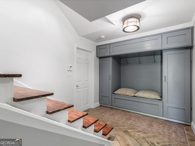 mudroom featuring crown molding, light parquet flooring, and vaulted ceiling