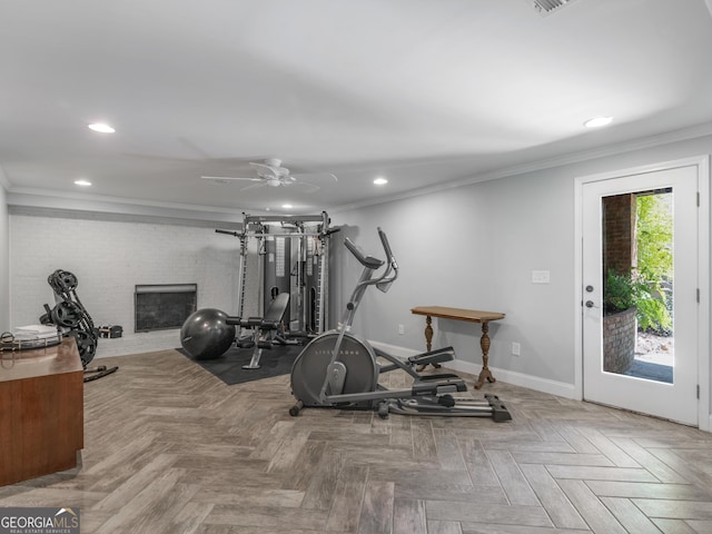 workout room featuring ceiling fan, a fireplace, ornamental molding, and parquet flooring