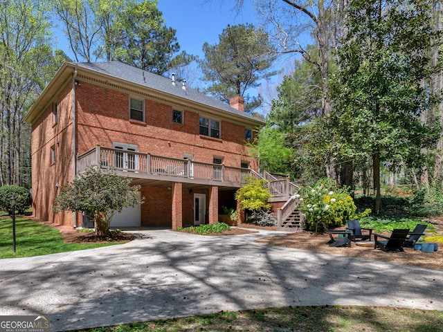 back of house with a deck and a garage