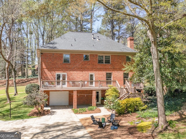 back of property featuring a garage and a wooden deck