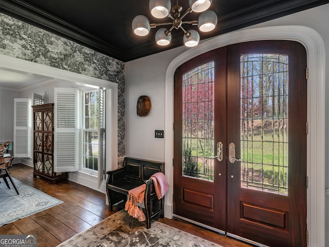 foyer entrance featuring dark hardwood / wood-style flooring, crown molding, french doors, and a chandelier