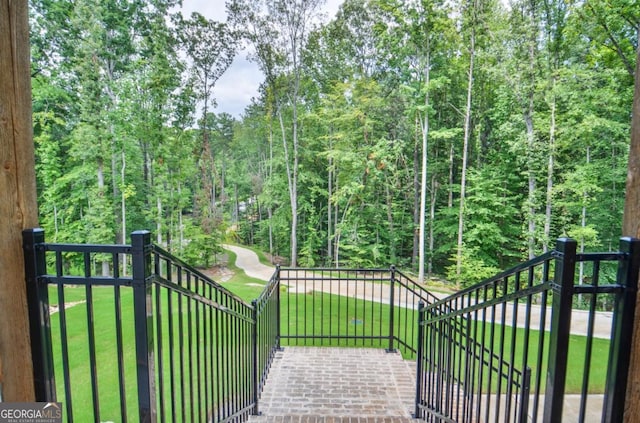 view of gate with a lawn