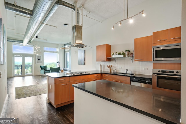 kitchen featuring decorative backsplash, appliances with stainless steel finishes, dark hardwood / wood-style flooring, french doors, and sink