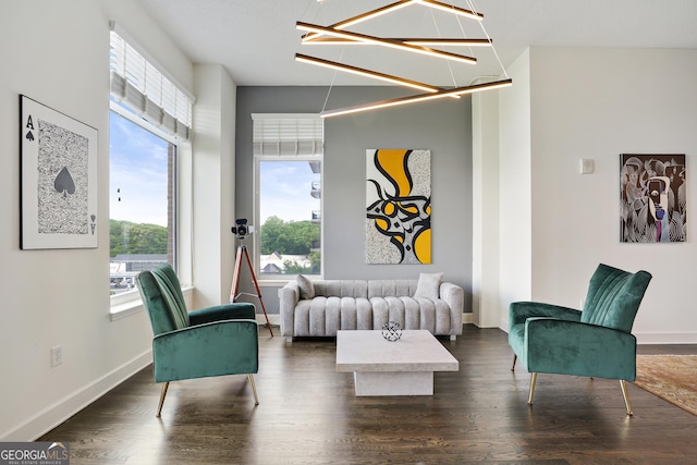 living area featuring a notable chandelier and dark hardwood / wood-style flooring