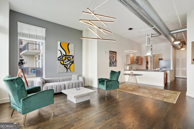 living room featuring a chandelier and dark hardwood / wood-style floors