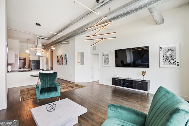 living room featuring dark wood-type flooring and a chandelier