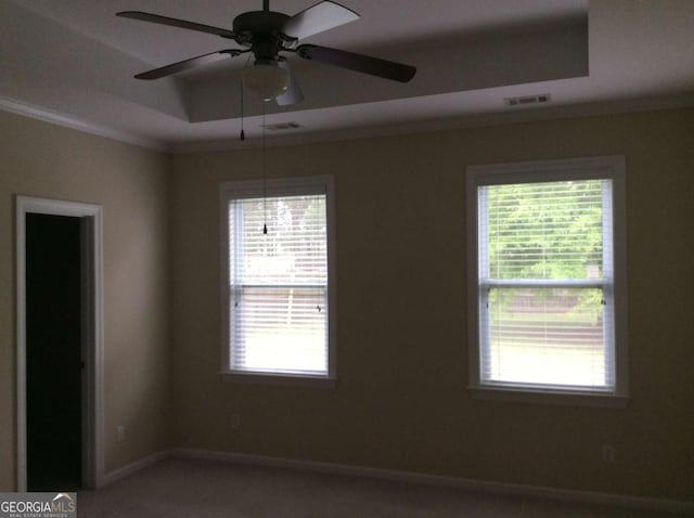 empty room with a tray ceiling and ceiling fan