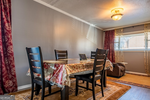 dining area with ornamental molding, a textured ceiling, and hardwood / wood-style flooring