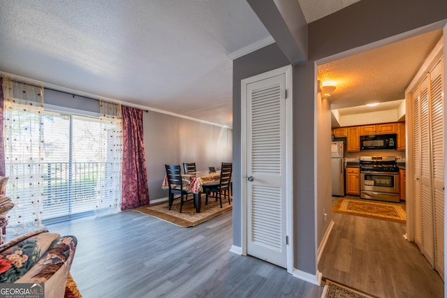 interior space featuring a textured ceiling, stainless steel appliances, and dark hardwood / wood-style floors