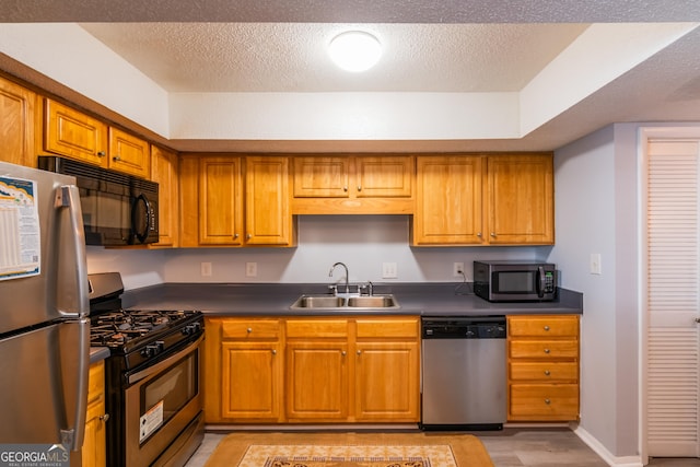 kitchen with a textured ceiling, sink, light hardwood / wood-style flooring, and black appliances