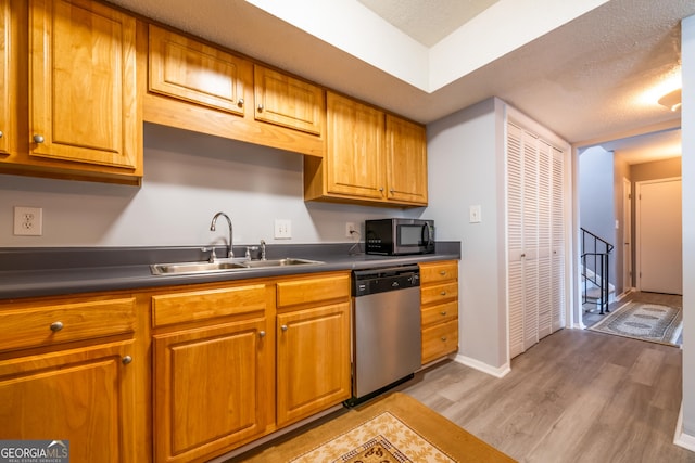 kitchen with stainless steel dishwasher, light hardwood / wood-style floors, sink, and a textured ceiling